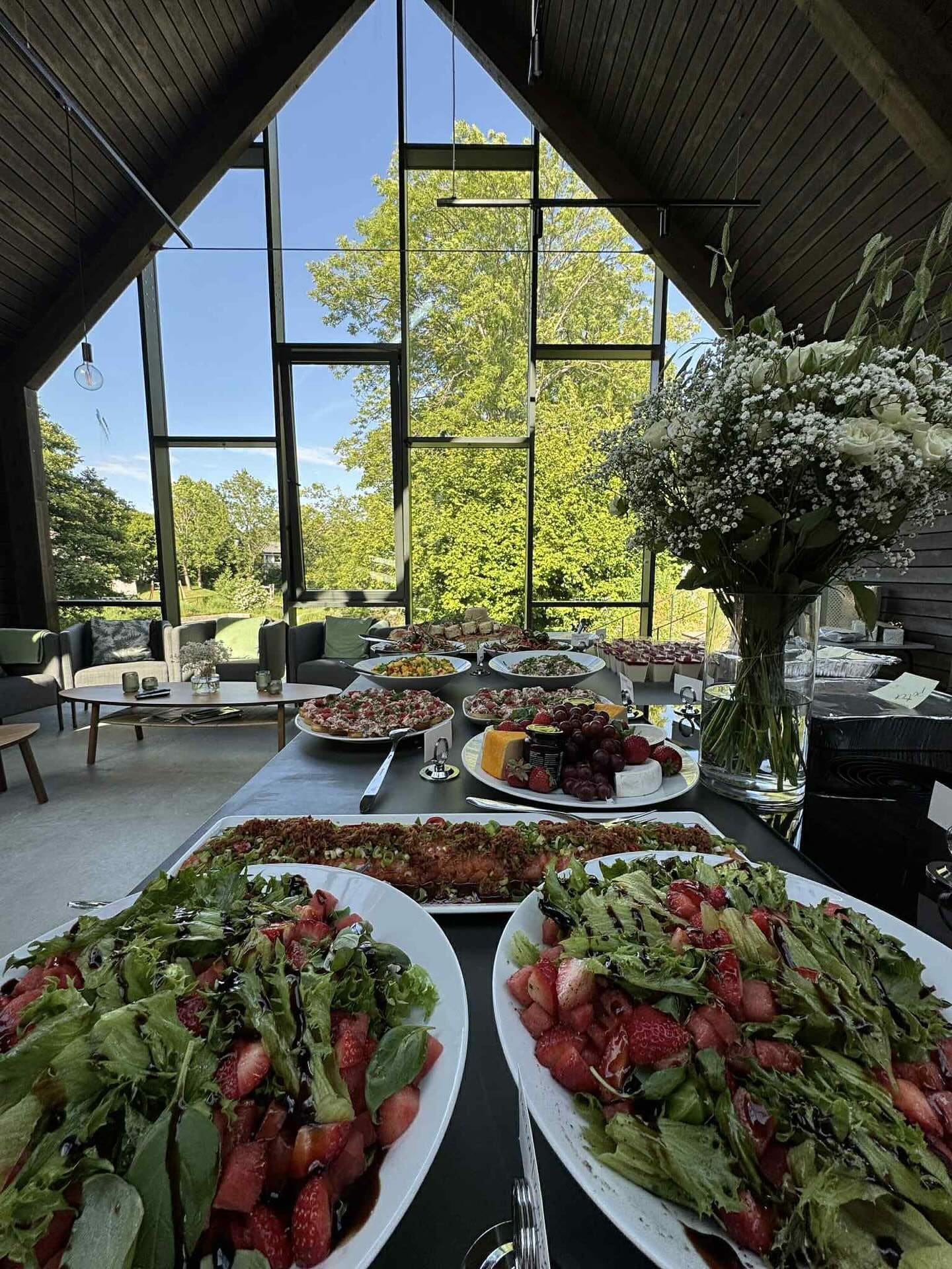Buffetbord med sommertapas dekket opp i et lyst lokale med store vinduer