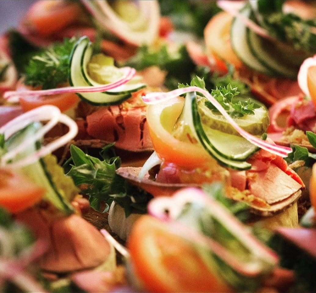 Fat med snitter av roastbeef og laks pyntet med agurk, tomat, roedloek og persille