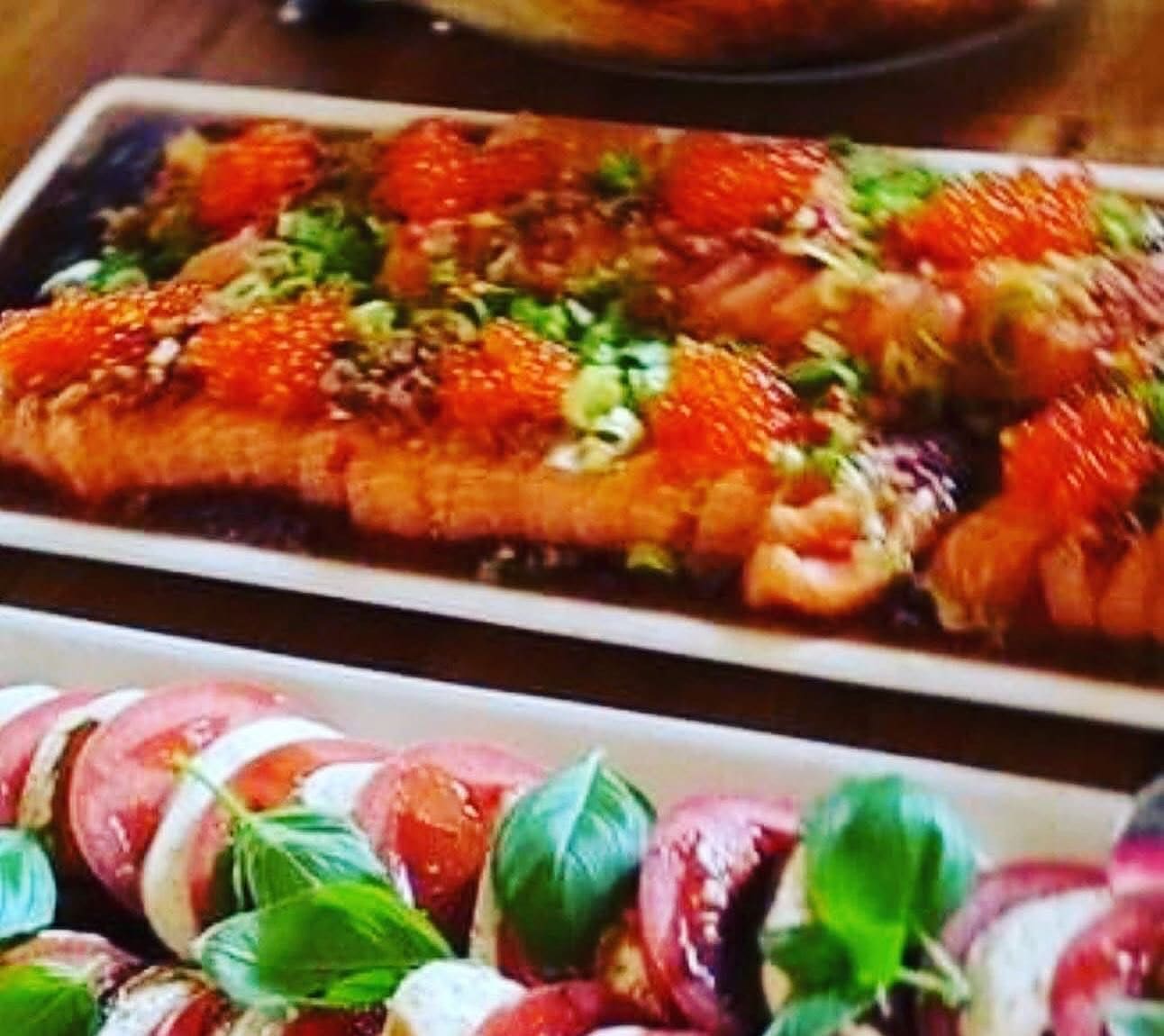 Fat med gravet laks og spyd av tomat, mozzarella og fersk basilikum lagt opp paa hvitt porselen